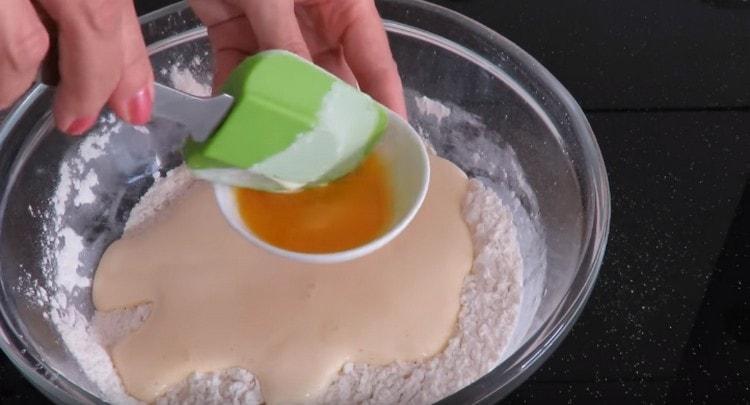 We spread the yeast and egg mass into the flour, add the orange juice.