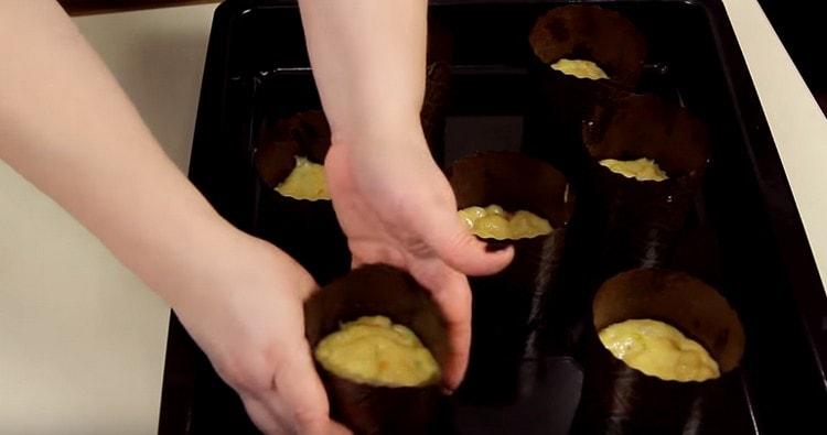 We divide the dough and put it in the molds for Easter cakes.