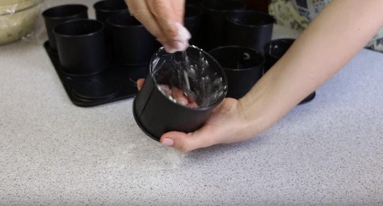 Les formes pour les gâteaux de Pâques sont graissées à l'huile et saupoudrées de farine.