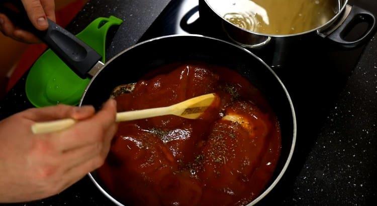 Agregue puré de tomate y hierbas provenzales a las pechugas de pollo en la sartén.