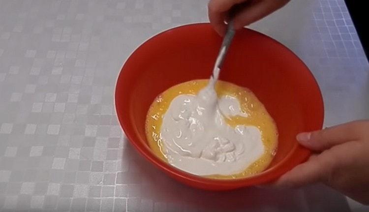 Agregue crema agria a la masa de huevo.