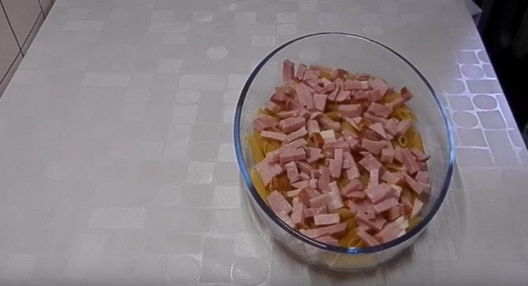 On top of the pasta we lay the ham cut into strips.