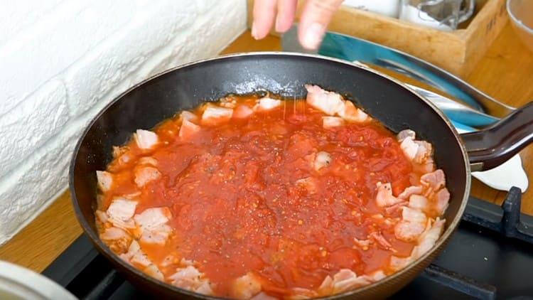 Amasar los tomates con una espátula, agregar sal, pimienta.
