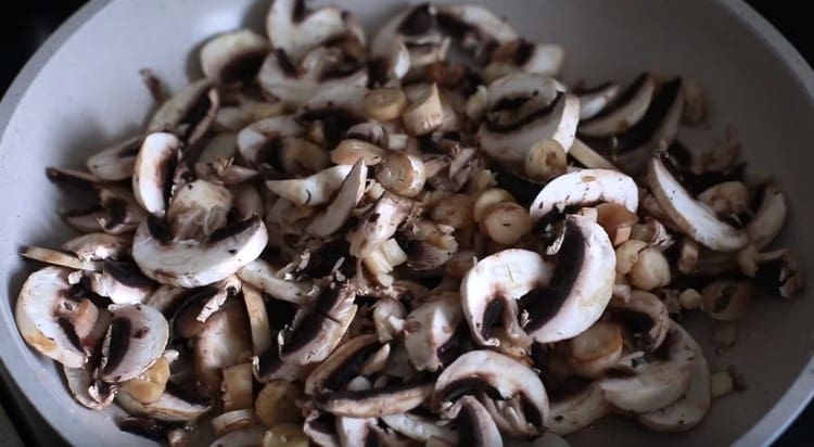 Pour a few tablespoons of water into the pan and spread the chopped mushrooms.