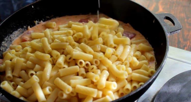 We verspreiden de gekookte pasta in de saus.