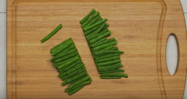Couper les haricots verts en deux.