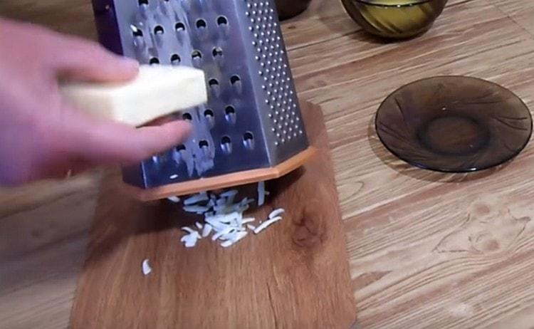 On a grater we rub the processed cheese.