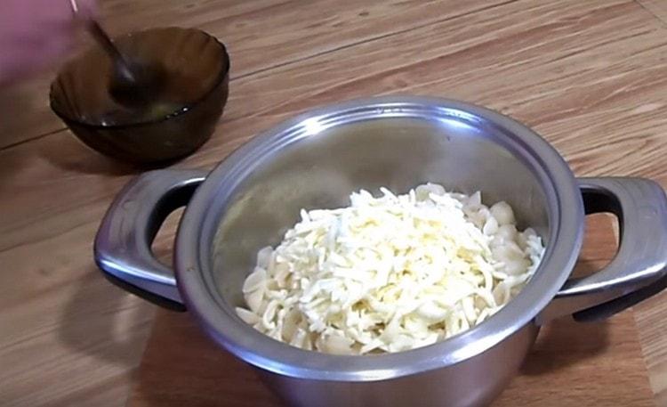 Add the grated processed cheese and mix the pasta.