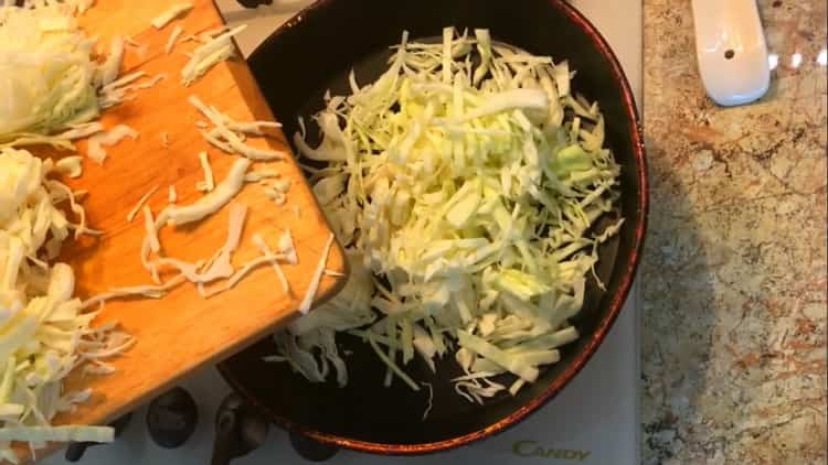 Fry the ingredients to make the cabbage filling for the pastries.