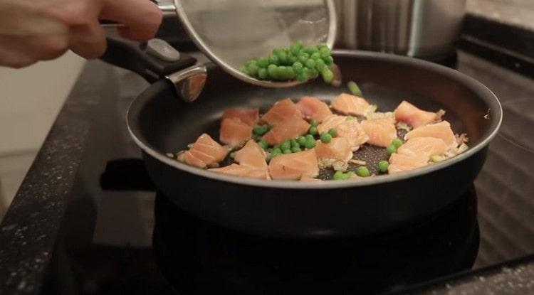 Dodajte zeleni grašak ribi i povrću.