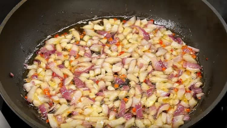Dans une poêle avec de l'huile d'olive, faites frire les oignons et les piments.