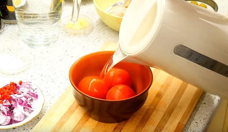 Vierte agua hirviendo sobre los tomates para pelarlos.