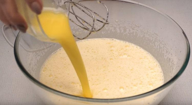 Tilsæt smeltet smør til æggemassen.