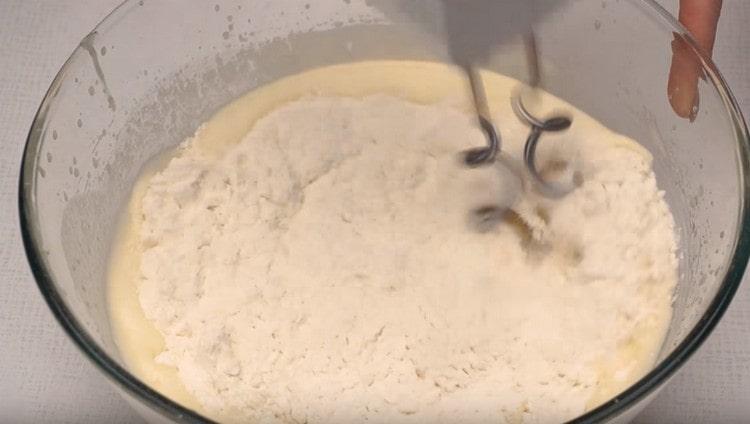 U dijelovima počinjemo unositi brašno i mijesiti tijesto.