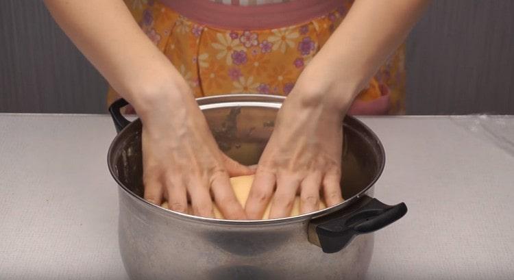 Again, return the dough to the pan so that it rises again.