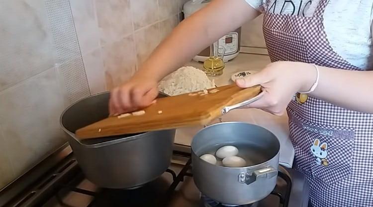 Dans le chaudron, étalez les oignons hachés pour les faire frire.