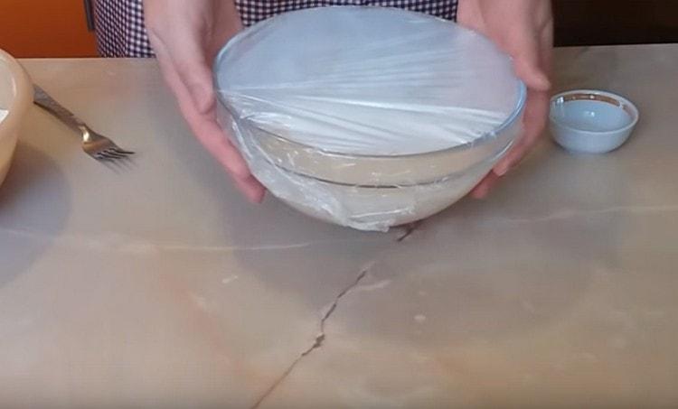 Tighten the bowl with a dough with cling film and let it stand in the heat for 15 minutes.