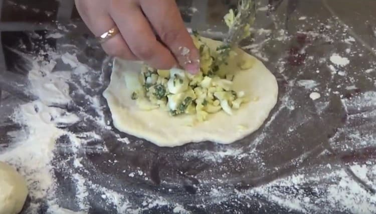 Amasar las bolas en pasteles, en el centro de los cuales extendimos el relleno.