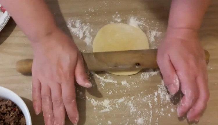 We roll out each blank with a rolling pin into a flat cake.