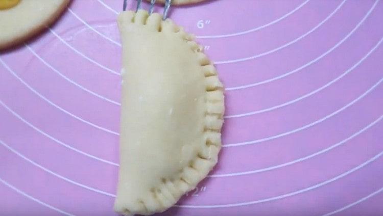Fold the dough in half, like a dumpling, and press the edges with a fork.