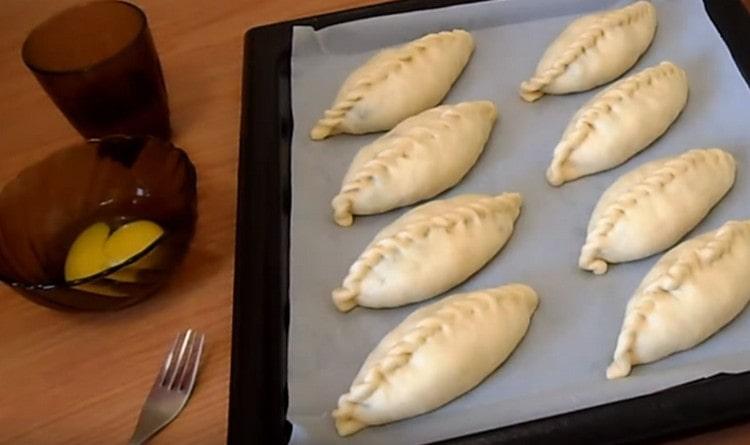 We spread the formed pies on a baking sheet covered with parchment.