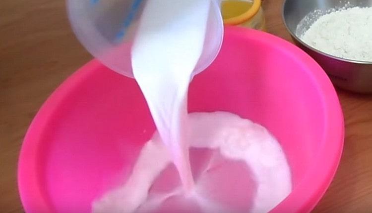 Pour warm milk into a bowl for kneading dough.