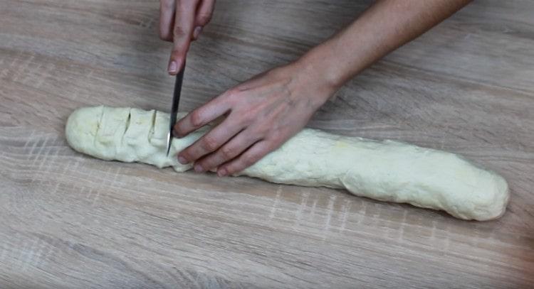 À partir de la pâte, nous formons un saucisson, le découpons en portions.