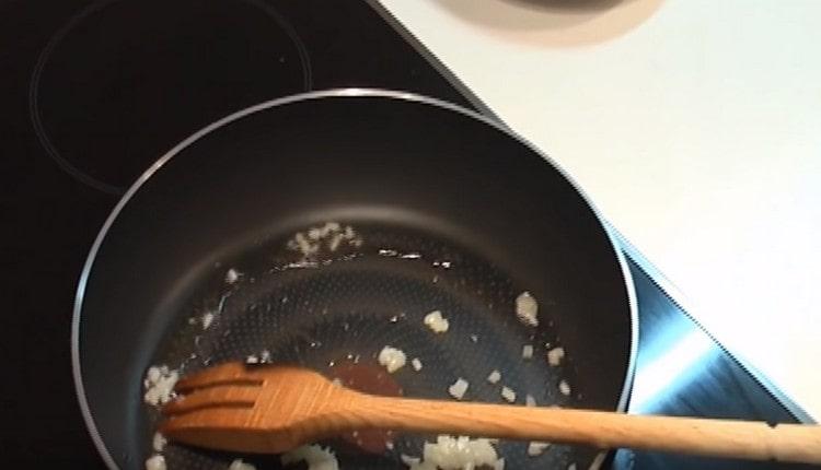Faire frire la moitié de l'oignon haché dans une poêle.