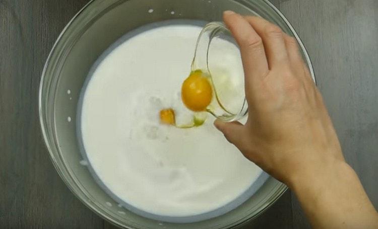Ajoutez deux œufs au mélange de levure.