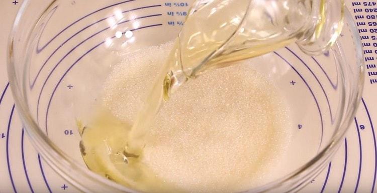 Dans un bol, mélanger le sucre et l'huile végétale.