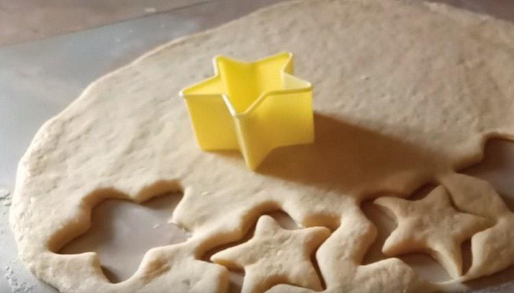 Using cookie cutters, squeeze the blanks for the crumpets from the dough.