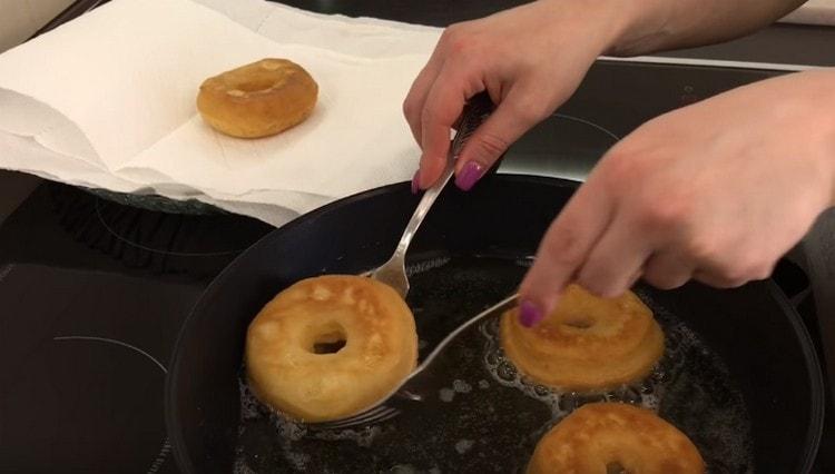 Fry the donuts until golden brown, then transfer to paper towels.
