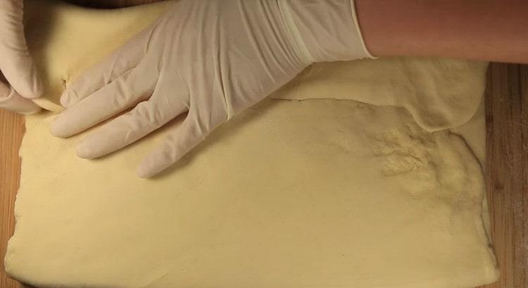 We make a seam on a rectangular sheet of dough, remove it with a rolling pin.