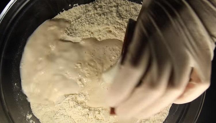 En una mezcla de harina con azúcar, agregue la masa de levadura, así como la leche.