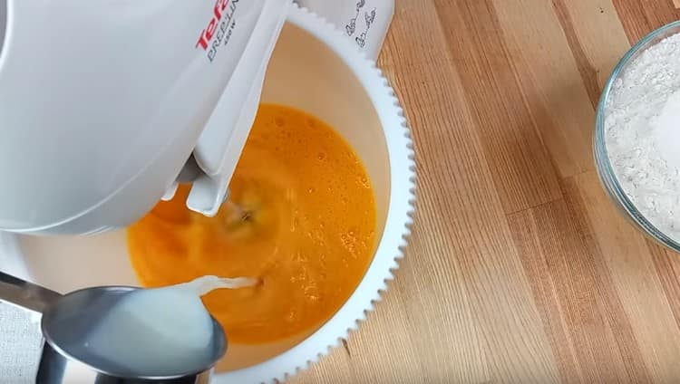 In the mixer bowl, beat the eggs, add milk, sugar, soda.