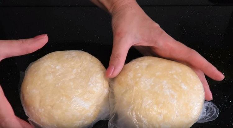 Nous divisons la pâte en deux parties identiques, les enveloppons dans des sacs et les mettons au réfrigérateur.