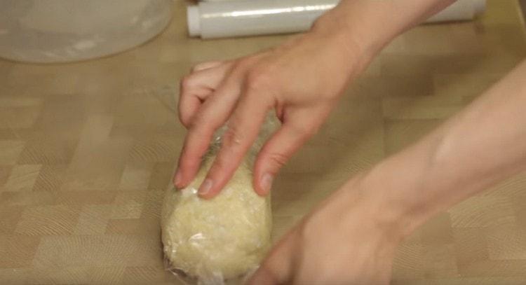 Serrant la pâte avec un film plastique, nous l'envoyons au réfrigérateur.