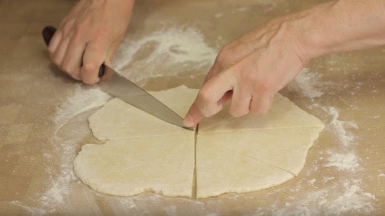 Ayant coupé la moitié de la pâte, nous roulons cette pièce en un cercle que nous avons coupé en triangles.