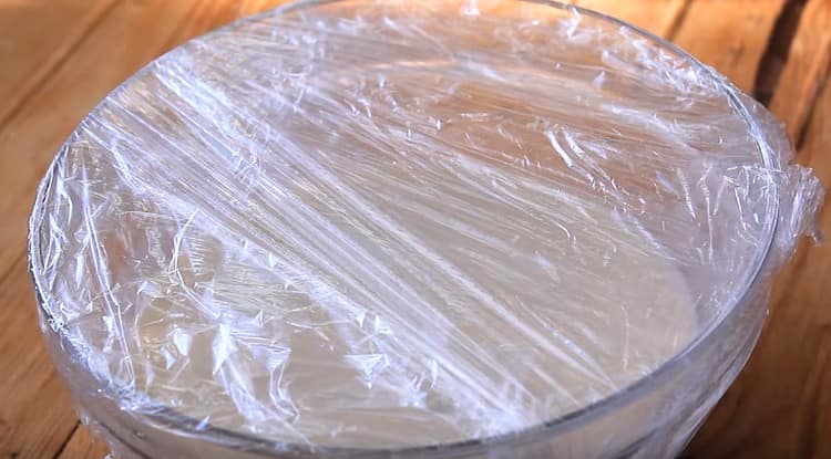 We cover the dough with cling film and set for an hour in a warm place.