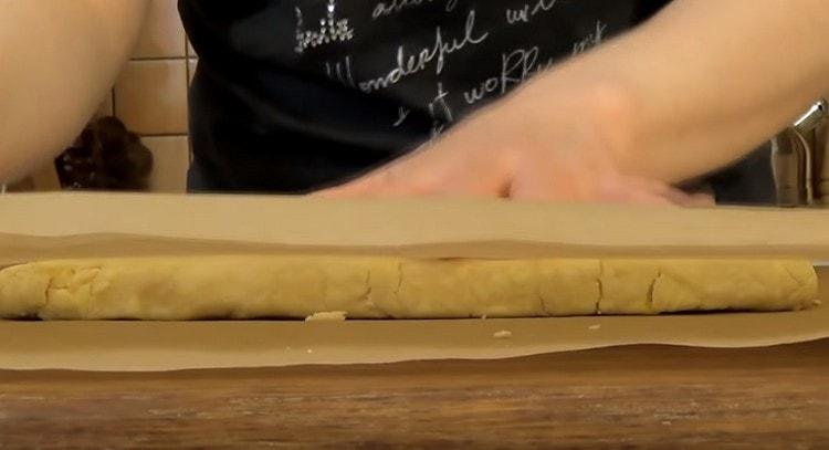 Nous recouvrons la couche de pâte avec une deuxième feuille de parchemin.