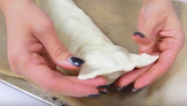 We shift the roll onto a baking sheet, pinch the edges.