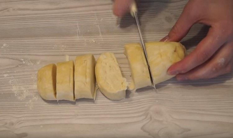 Nous roulons chaque partie de la pâte en un rouleau et la coupons en morceaux.