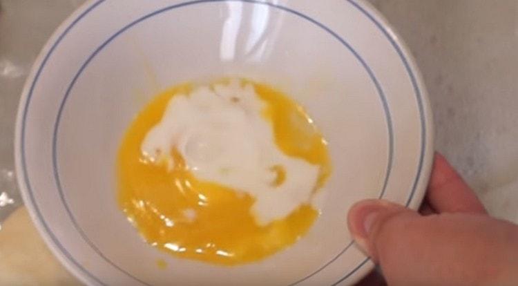 Dans un bol, nous combinons le jaune d'oeuf avec du lait.