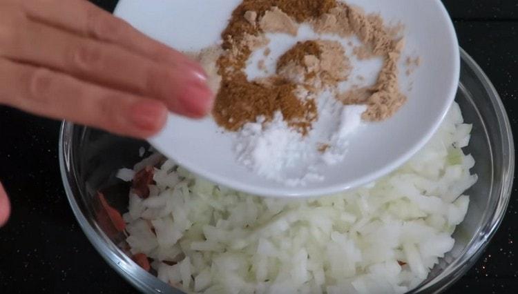 Agregue especias, sal y pimienta a la cebolla con carne.
