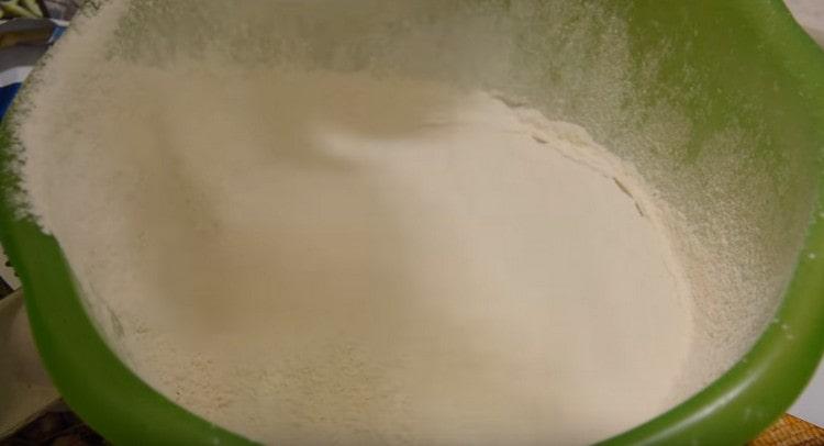 Tamizar la harina en la masa de levadura de leche.