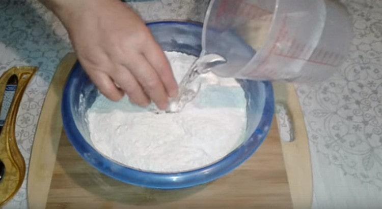 U mješavinu brašna unosimo toplu vodu.