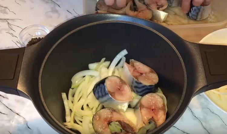 Put a layer of onion and fish in a saucepan.