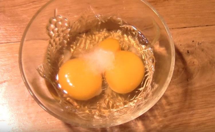 In the bowl, beat the eggs, add salt to them and slightly beat.