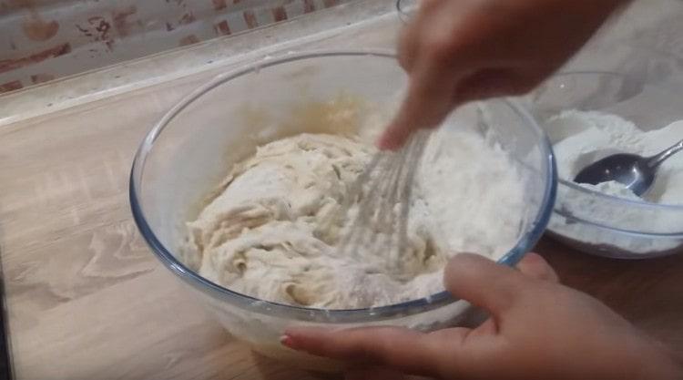 Petit à petit, nous commençons à ajouter de la farine et à pétrir la pâte.