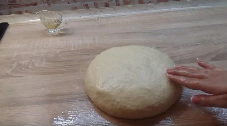 Then knead the dough on the table, greasing it and hands with vegetable oil.